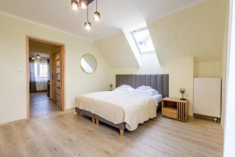 Szeroki widok sypialni apartamentu z przejściem do części dziennej